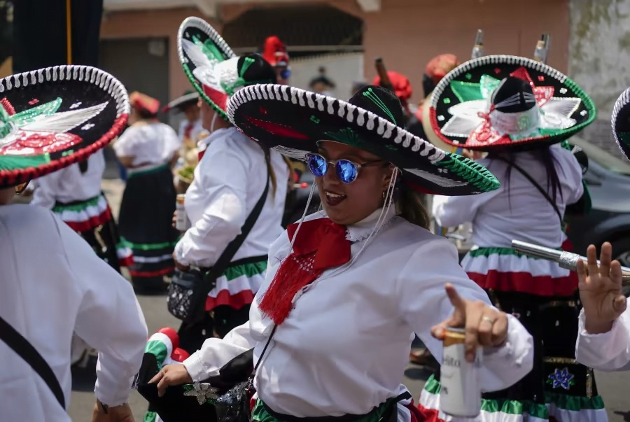 People in traditional attire with sombreros participating in a festive event.