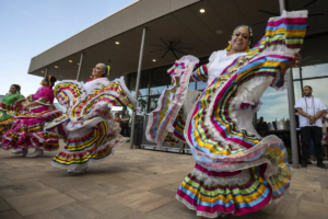 Colorful dancers in traditional attire performing during a festive event.